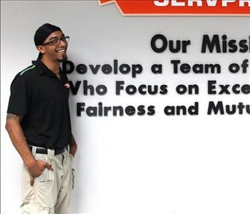 Tech standing in front of our mission statement